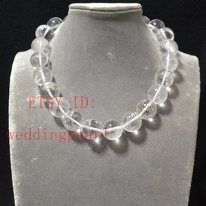 May include: A clear crystal bead necklace with a silver clasp. The necklace is on a white mannequin. The text "ETSY ID: weddingpearl" is visible in the image.