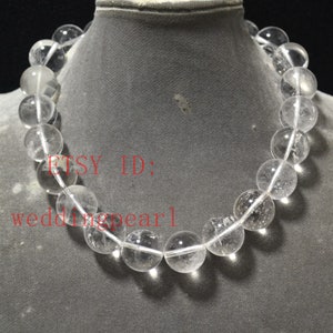 May include: A clear crystal bead necklace with a white string. The beads are round and have a smooth, polished finish. The necklace is displayed on a mannequin's neck. The text "ETSY ID: weddingpearl" is visible in the image.