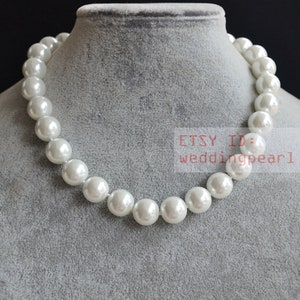 May include: A white pearl necklace displayed on a gray mannequin. The necklace is composed of large, round, lustrous pearls. The Etsy ID is weddingpearl.