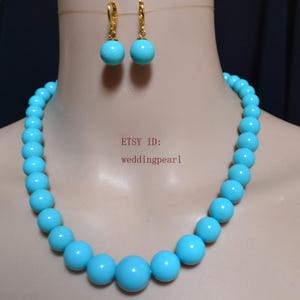 May include: A turquoise bead necklace and matching earrings set. The necklace and earrings feature large, round beads in a vibrant turquoise color. The earrings have gold-colored hooks. The Etsy ID is weddingpearl1.