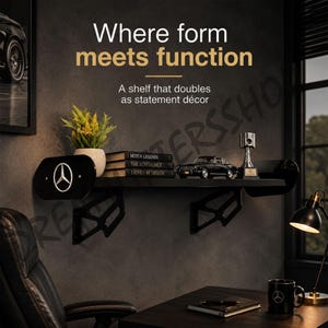 May include: A black wall-mounted shelf featuring the Mercedes-Benz logo on the side panel. The shelf holds a potted plant, three books titled Motor Legends, The Automobile, and Driven by Design, a black model car, and a silver piston trophy.