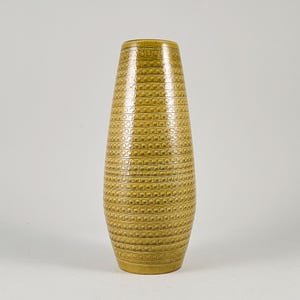 May include: A tall, tapered ceramic vase in a mustard yellow glaze. The exterior surface is decorated with a repeating pattern of horizontal bands featuring small, raised circular indentations that wrap around the entire body of the vessel.