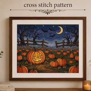 May include: A framed cross stitch pattern featuring a Halloween scene with a large jack-o'-lantern in the foreground, a pumpkin patch, a wooden fence, bare trees, bats, and a crescent moon against a dark blue night sky with stars.