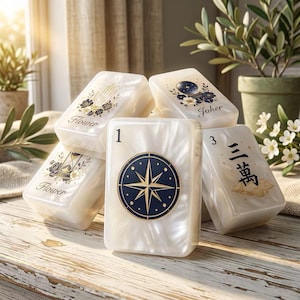 Può includere: Un set di tessere da mahjong bianco perlaceo con varie illustrazioni tra cui una bussola, una sfera di cristallo, una clessidra e una mano, con etichette come Flower, Joker, 1, 3 e caratteri cinesi stampati sulla superficie.