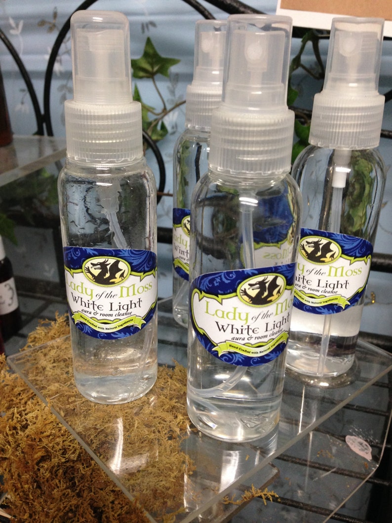 Pode incluir: Quatro garrafas de vidro transparente com pulverizadores cheias de um l&iacute;quido transparente. As garrafas t&ecirc;m r&oacute;tulos com o texto "Lady of the Moss White Light aura & room cleanse".