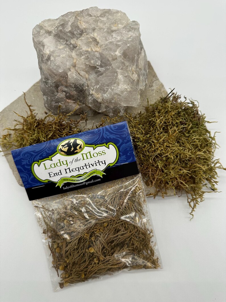 Puede incluir: Una peque&ntilde;a bolsa de pl&aacute;stico transparente llena de hierbas marrones secas y etiquetada "Lady of the Moss End Negativity Hand Crafted and Blessed Herbs ladyofthemoss@gmail.com"