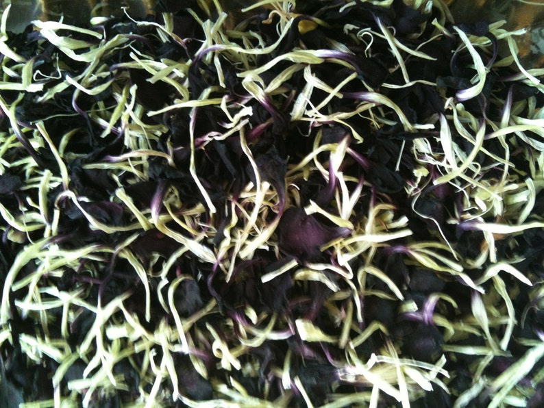 May include: A close-up of dried flower petals, some are a deep purple and others are a pale cream color.