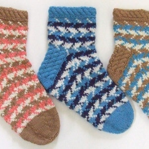 Puede incluir: Tres pares de calcetines de punto con un patrón de pata de gallo. Los calcetines son en tonos de marrón, rosa, azul, blanco y azul marino.