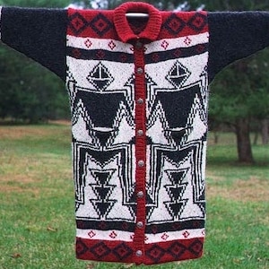 May include: A long, black and white knitted cardigan with a red and black geometric pattern. The cardigan has a button closure and a collar.