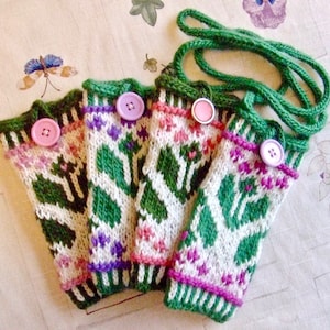 May include: Four knitted green, white, and pink bottle cozies with pink buttons. The cozies are attached to a green knitted strap.
