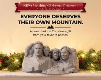 May include: A grey, sculpted stone-like figurine featuring four distinct human faces carved into a mountain-shaped base. Text above reads: NEW: Matching Christmas Ornament, EVERYONE DESERVES THEIR OWN MOUNTAIN. A one-of-a-kind Christmas gift from your favourite photos.
