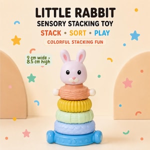 Puede incluir: Un juguete sensorial apilable con una cabeza de conejo morado claro y cuatro anillos texturizados en color melocotón, amarillo, verde claro y azul. El juguete mide 9 cm de ancho por 8,5 cm de alto. Texto: LITTLE RABBIT SENSORY STACKING TOY STACK SORT PLAY.