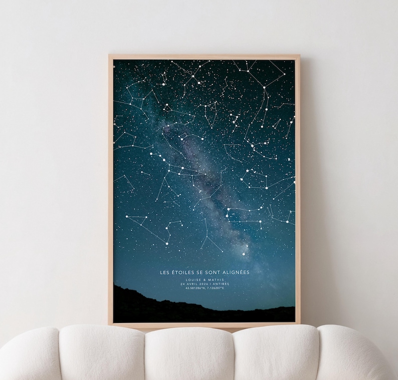 Op de afbeelding: Ingelijste print met een donkerblauwe nachthemel vol witte sterren en sterrenbeelden. De Melkweg is zichtbaar. De tekst "LES &Eacute;TOILES SE SONT ALIGN&Eacute;ES" staat onderaan, samen met namen en co&ouml;rdinaten. De lijst is licht van hout.