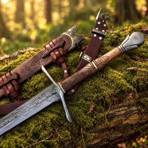 May include: A sword with a patterned metal blade featuring a small green stone at the crossguard, a wooden handle with intricate carvings, and a rounded metal pommel. It is accompanied by a brown leather scabbard with ornate metal accents.