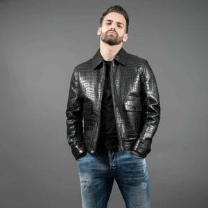 Jaqueta bomber masculina em couro preto com estampa de crocodilo e detalhes em malha canelada de couro bovino legítimo.