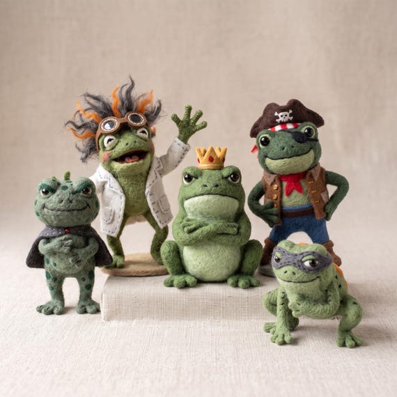 Tiny hand-needled wool frog dressed as a pirate, ninja, or scientist — absurdly detailed miniature craft that screams 'a real person made this at 2am.'