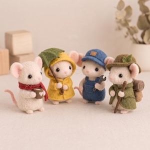 May include: Four needle-felted mouse figurines. One wears a red scarf and holds a mug. One wears a yellow raincoat and holds a green umbrella. One wears blue overalls and a cap, holding a wrench. One wears a green coat and hat, carrying a pack.