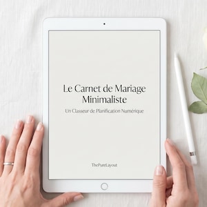Peut inclure: Une tablette blanche affichant le texte Le Carnet de Mariage Minimaliste et Un Classeur de Planification Numérique avec ThePureLayout en bas, accompagnée d'un stylet blanc, d'une rose blanche et d'un petit plat de trombones argentés.
