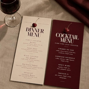 Könnte beinhalten: Eine cremefarbene Speisekarte und eine dunkelrote Cocktailkarte, jeweils mit einer frischen Kirsche garniert. Die Speisekarte enthält Gerichte wie Burrata, Caesar Salad, Filet Mignon und Schokoladenmousse. Die Cocktailkarte listet Getränke.