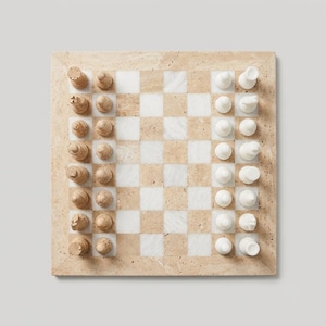 May include: A square chess set featuring a board with alternating beige travertine and white marble squares. One side has beige travertine chess pieces, while the other side features smooth white marble chess pieces, all arranged in their starting positions.