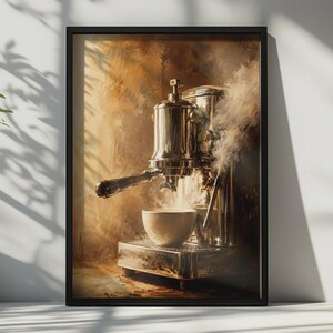 May include: A framed wall art print depicting a metallic espresso machine brewing coffee into a white ceramic cup. The machine is polished silver with a dark handle, emitting visible steam against a warm, textured, golden-brown painted background.