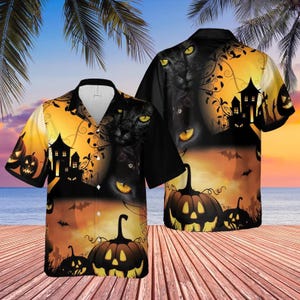 May include: A short-sleeved button-down shirt featuring a Halloween-themed print with a black cat, a haunted house, and glowing jack-o'-lanterns against an orange and black sunset background. The shirt has a collar and a front button closure.