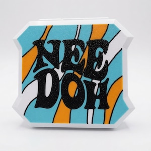 May include: A white, octagonal-shaped plastic container featuring a textured surface with a wavy pattern of light blue and orange stripes. The black, glittery text "NEE DOH" is prominently displayed in the center of the front-facing panel.