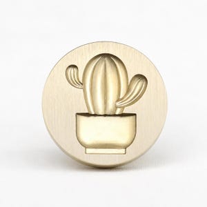 Stempel met afbeelding van een cactus in een pot, gemaakt van massief messing met reliëf en plantenmotief.