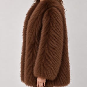 May include: A long-sleeved, hip-length coat made of thick, textured brown faux fur. The garment features a voluminous, plush appearance with a dense pile and a wide, open collar design that drapes down the front, providing a full, layered look.
