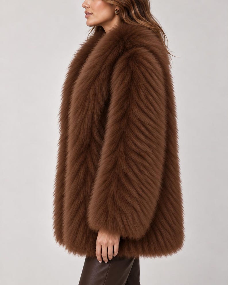 May include: A long-sleeved, hip-length coat made of thick, textured brown faux fur. The garment features a voluminous, plush appearance with a dense pile and a wide, open collar design that drapes down the front, providing a full, layered look.