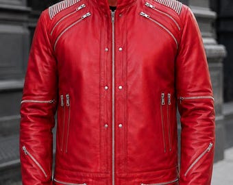 Puede incluir: Una chaqueta de cuero rojo vibrante con cuello alto, cierre central de cremallera con botones a presión y múltiples cremalleras metálicas plateadas en el pecho, las mangas y la cintura. Los hombros tienen detalles acanalados y los puños son elásticos.