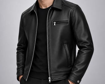 Puede incluir: Una chaqueta negra con acabado liso, cuello clásico, cremallera frontal plateada de longitud completa y un bolsillo horizontal con cremallera en el pecho. Las mangas largas tienen puños abotonados y cuenta con dos bolsillos laterales.