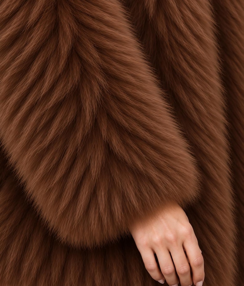May include: A long-sleeved garment made of thick, plush, brown faux fur. The material features a dense, shaggy texture with long, soft fibers that create a layered, voluminous appearance across the entire surface of the fabric, showing a deep brown tone.