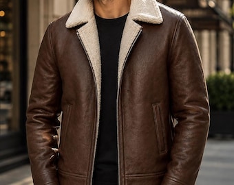 Puede incluir: Una chaqueta de cuero marrón oscuro con cuello y forro interior de sherpa en color crema. La chaqueta cuenta con una cremallera metálica plateada de arriba a abajo, mangas largas con puños cosidos y dos bolsillos verticales frontales.