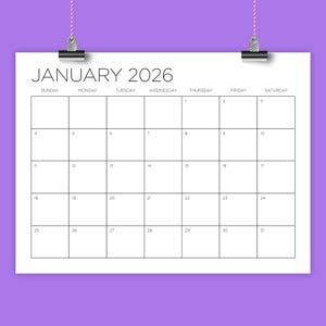 May include: A white calendar page for January 2026, with a grid layout for each day of the month. The word "JANUARY 2026" is at the top. The calendar is held by a silver clip and a pink string.