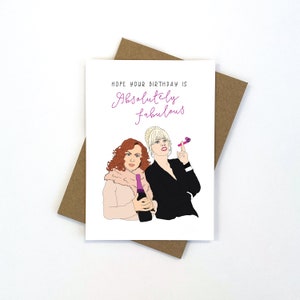 May include: A birthday card featuring a pink and white illustration of two women. The text on the card reads "Hope your birthday is Absolutely fabulous".
