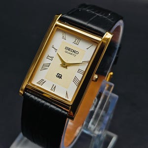 Reloj rectangular Seiko vintage: esfera romana, correa de cuero negro, cuarzo restaurado