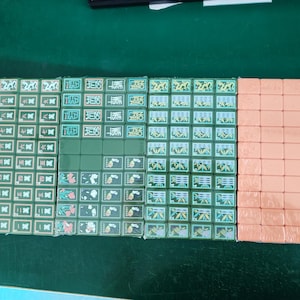 May include: A set of rectangular mahjong tiles arranged in four columns. Three columns feature green tiles with various engraved symbols, Chinese characters, and floral patterns. The fourth column consists of plain, solid peach-colored tiles.