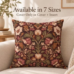 May include: A square throw pillow featuring a dark burgundy background with a symmetrical floral pattern in shades of cream, pink, and sage green. Text above reads Available in 7 Sizes and Cover Only or Cover + Insert.