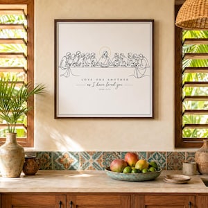 Peut inclure: Une impression d'art murale carrée présentant un dessin au trait noir de la Cène avec une auréole dorée au-dessus de la figure centrale. Sous l'illustration, le texte indique : LOVE ONE ANOTHER as I have loved you. JOHN 15:12 en police serif.