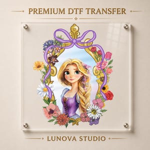 May include: A premium DTF transfer featuring a cartoon illustration of a blonde character with long hair in a purple dress, framed by a gold ornate mirror adorned with colorful flowers and a purple ribbon, with text reading PREMIUM DTF TRANSFER and LUNOVA STUDIO.