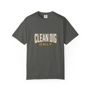 Op de afbeelding: Een antracietgrijs T-shirt met korte mouwen en de tekst CLEAN DIG ONLY in het wit met een gouden omlijning op de borst. Het shirt heeft een ronde hals en een standaard pasvorm, met een klein merklabel zichtbaar bij de binnenkant van de nek.