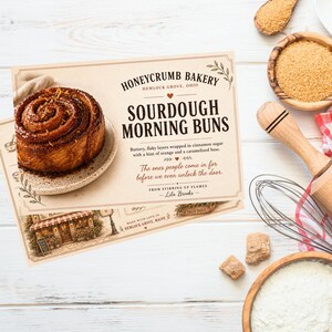 Könnte beinhalten: Eine rechteckige Karte mit einem Foto eines goldbraunen Sauerteig-Morgenbrötchens auf einem kleinen Teller. Der Text lautet Honeycrumb Bakery, Sourdough Morning Buns, und enthält eine Beschreibung des Gebäcks, ein Zitat und die Autorin Lila Brooks.