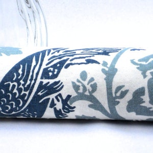 May include: A white fabric with a blue and light blue floral pattern. The fabric features a stylized floral design with leaves and flowers.