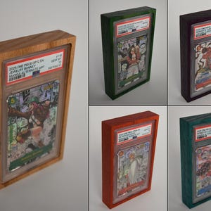 May include: Five rectangular wooden display frames, each housing a slabbed collectible trading card. The frames feature distinct wood finishes in natural light brown, dark green, deep purple, reddish-orange, and teal, showcasing various One Piece manga art cards.