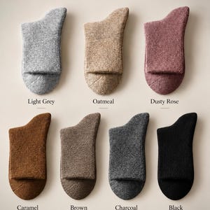 May include: Seven pairs of 98% Merino Wool Socks in light grey, oatmeal, dusty rose, caramel, brown, charcoal, and black. The text reads 98% Merino Wool Socks, Soft, Warm, Breathable, and Natural Comfort for Everyday.