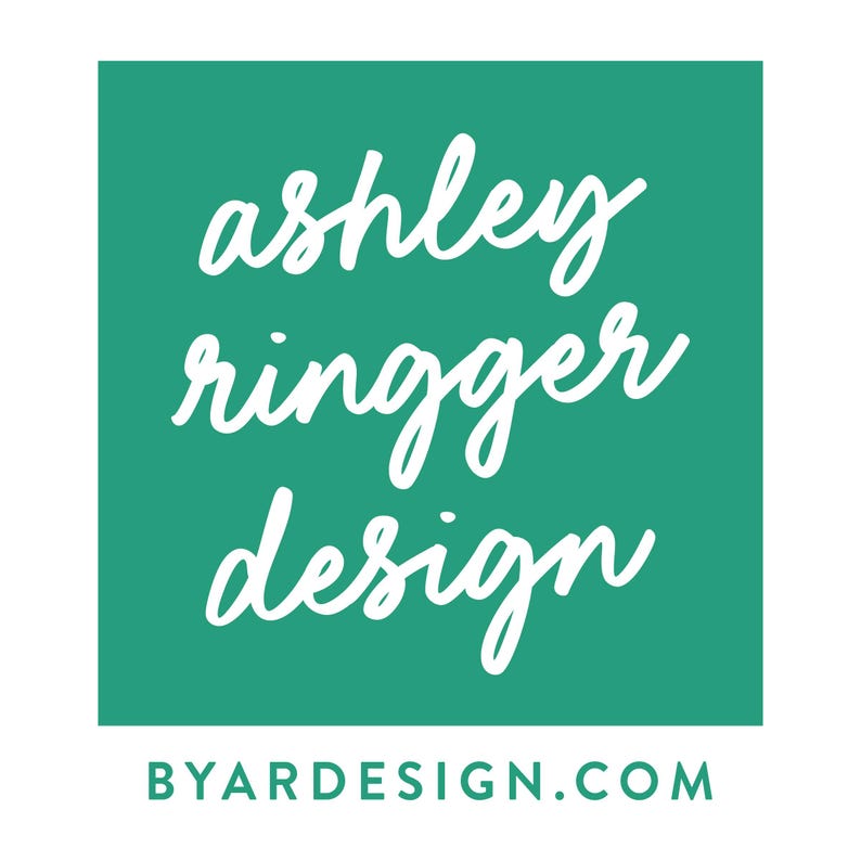 May include: A teal green square with white text that reads "ashley ringger design" and "BYARDESIGN.COM" in a smaller font.