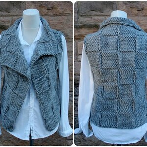 May include: A gray knitted vest with a square pattern on the back and a draped collar in the front.