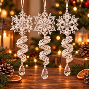 May include: Three hanging ornaments featuring intricate cream-colored lace snowflakes at the top, connected to a spiraling lace ribbon structure, and finished with a clear, teardrop-shaped crystal pendant at the bottom of each piece.