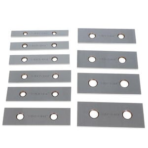 May include: A collection of twelve rectangular silver-toned metal plates arranged in two columns. Each plate features two circular holes and is engraved with specific dimensions such as 1/8x1/2x4", 1/8x5/8x4", 1/8x3/4x4", 1/8x7/8x4", 1/8x1x4", and 1/8x1-1/8x4".